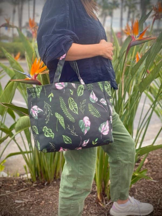 dark green tote bag with house plant leaves all over