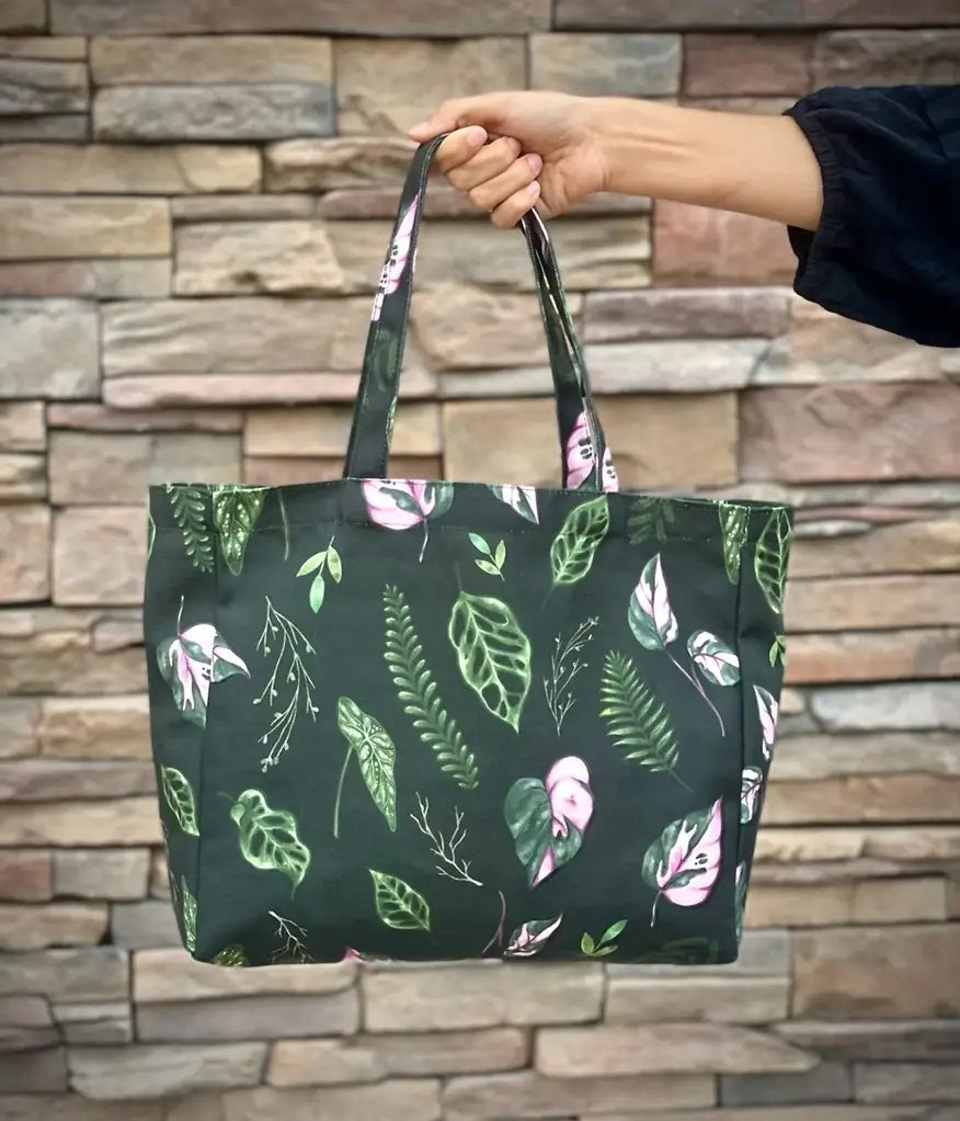 dark green tote bag with house plant leaves all over